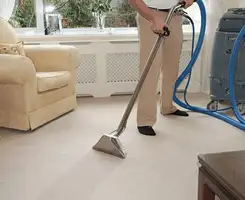 Carpet cleaning professional removing dirt and stains with a hot-water extraction tool in a home, Fort Collins, CO.